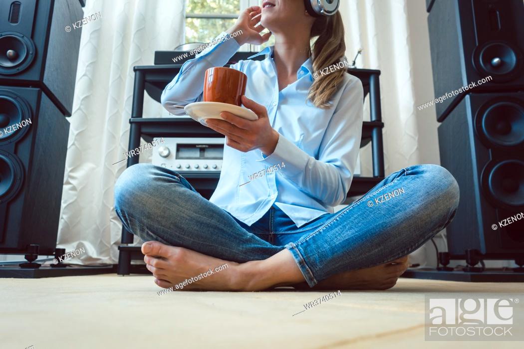 Stock Photo: Woman listening to music from a Hi-Fi stereo at home.