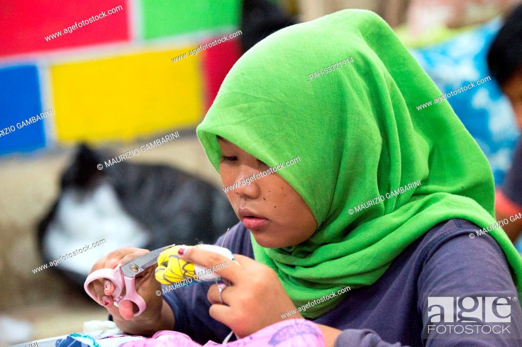 Stock Photo: A former street kid sews at a workshop in Jakarta,  Indonesia, 03 November 2014. Actress Natalia Woerner supports Kindernothilfe.
