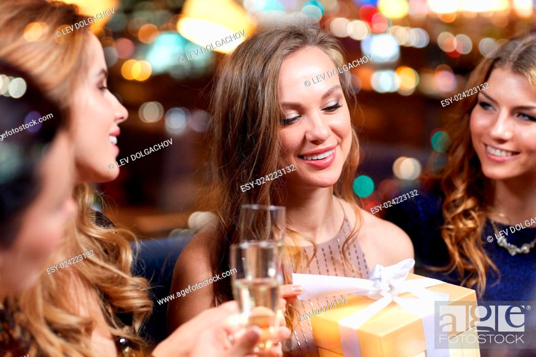Stock Photo: celebration, friends, bachelorette party, birthday and holidays concept - happy women with champagne glasses and gift box at night club.