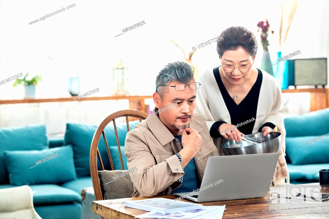 Stock Photo: Middle-aged couples using laptop at home.
