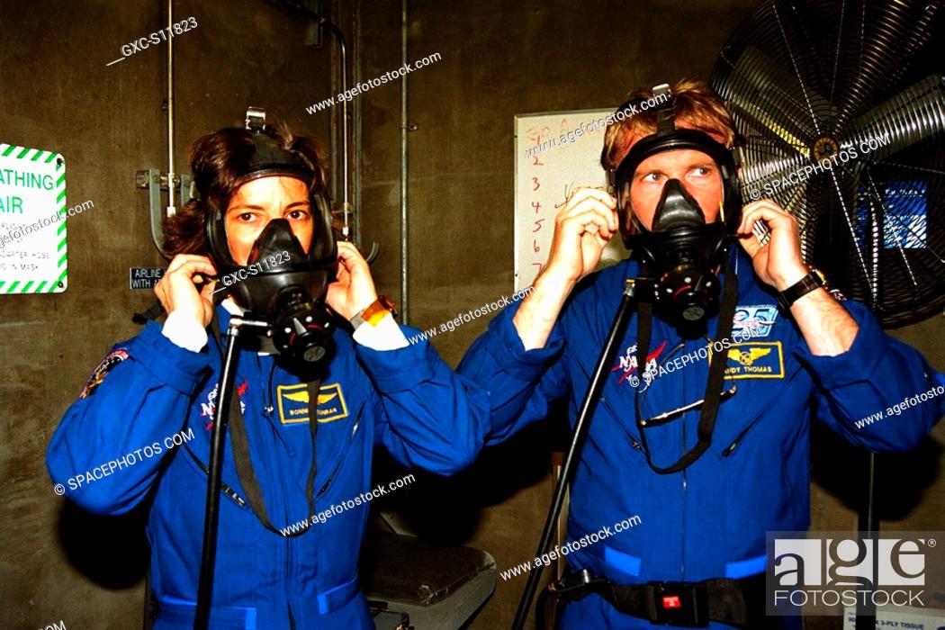 Stock Photo: 01/09/1998 --- STS-89 Mission Specialists Bonnie Dunbar, Ph.D., and Andrew Thomas, Ph.D., check out oxygen masks in the bunker at KSC’s Launch Pad 39A.