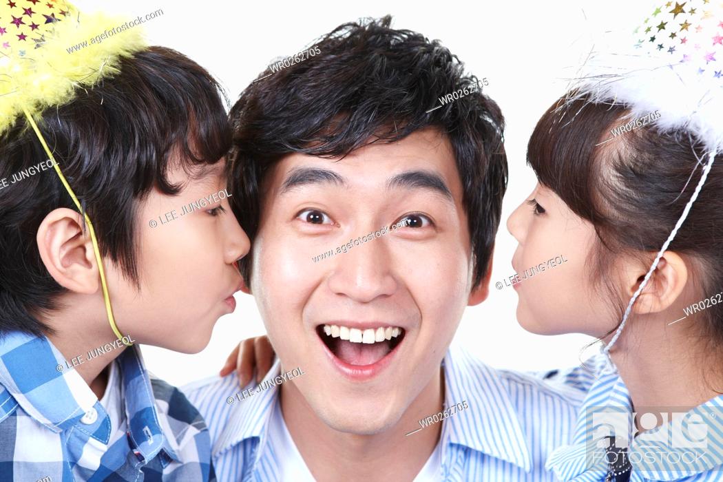 Photo de stock: boy and girl kissing father's cheek.