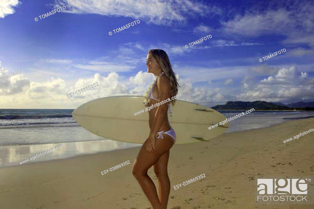 Stock Photo: teenage girl in white bikini and flower lei with her surfboard at Kailua beach.