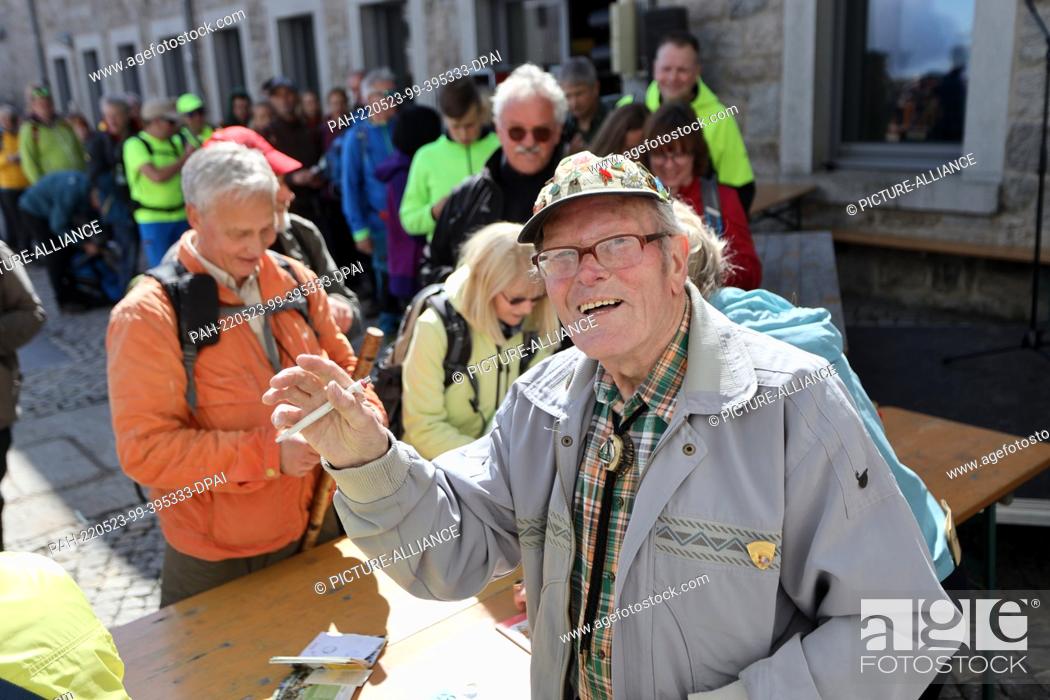 Imagen: 22 May 2022, Saxony-Anhalt, Schierke: Record hiker Benno Schmidt, alias Brocken-Benno, signs books during a ceremony. The record hiker celebrated his 9000th.