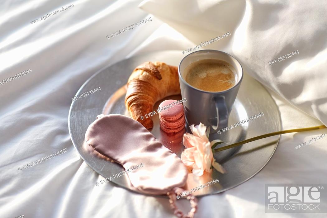 Imagen: croissant, coffee and eye sleeping mask in bed.