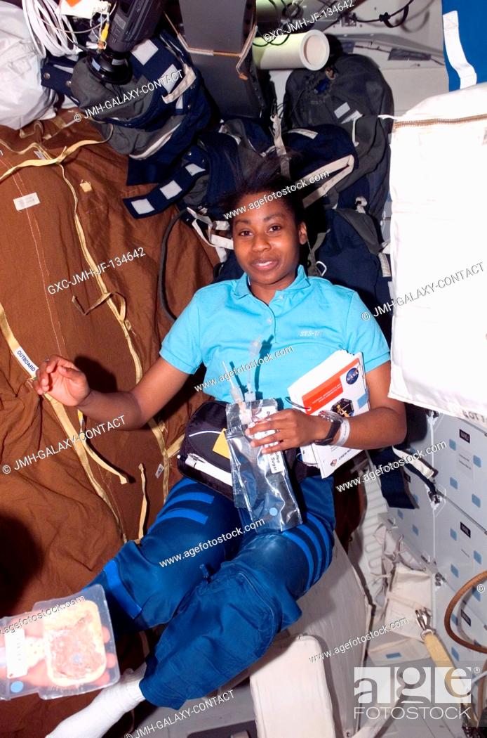 Stock Photo: Astronaut Stephanie D. Wilson, STS-121 mission specialist, holds a drink container and a procedures checklist on the middeck of the Space Shuttle Discovery.
