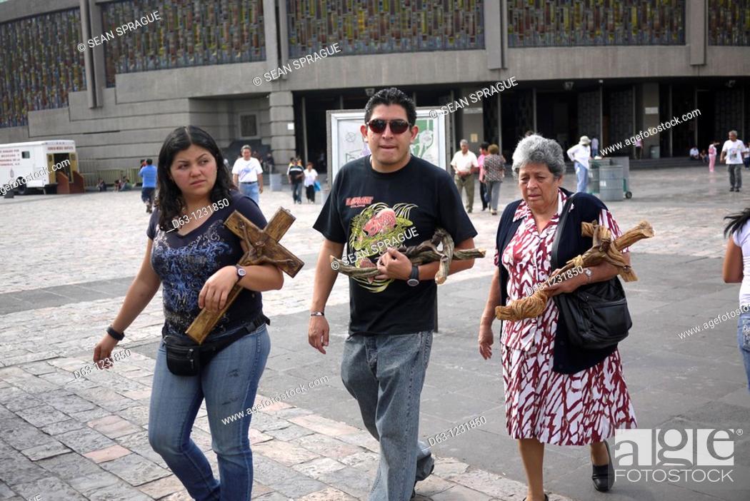 Stock Photo: Mexico, Mexico City, Basilica of Guadalupe. Pilgrims carrying religious statues which have been blessed by a priest.