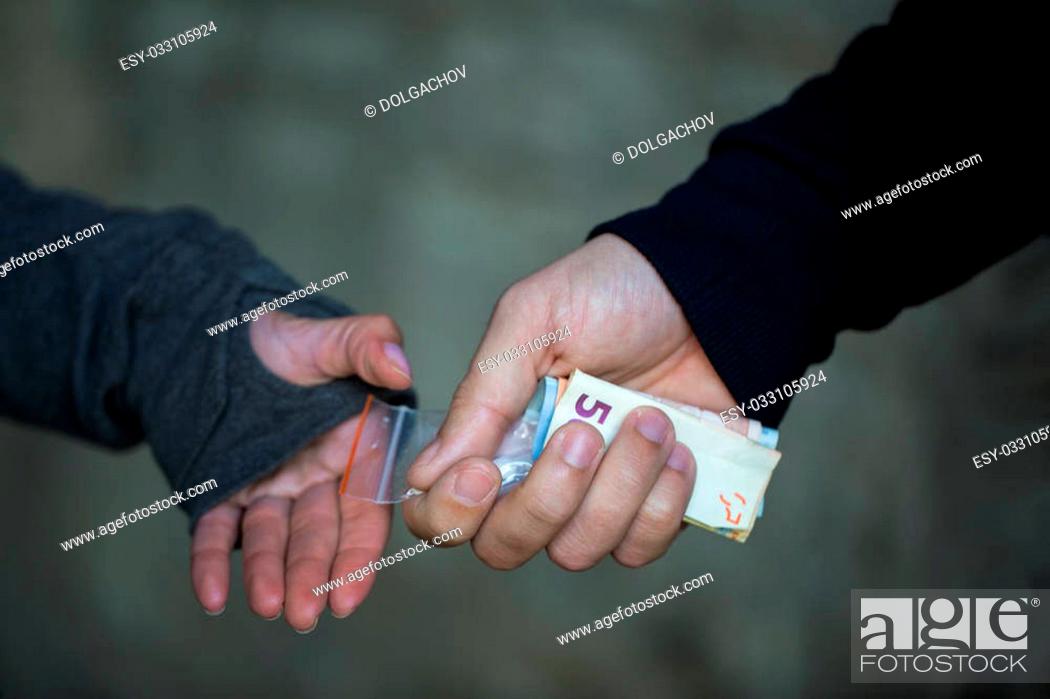 Stock Photo: drug trafficking, crime, addiction and sale concept - close up of addict with money buying dose from dealer on street.