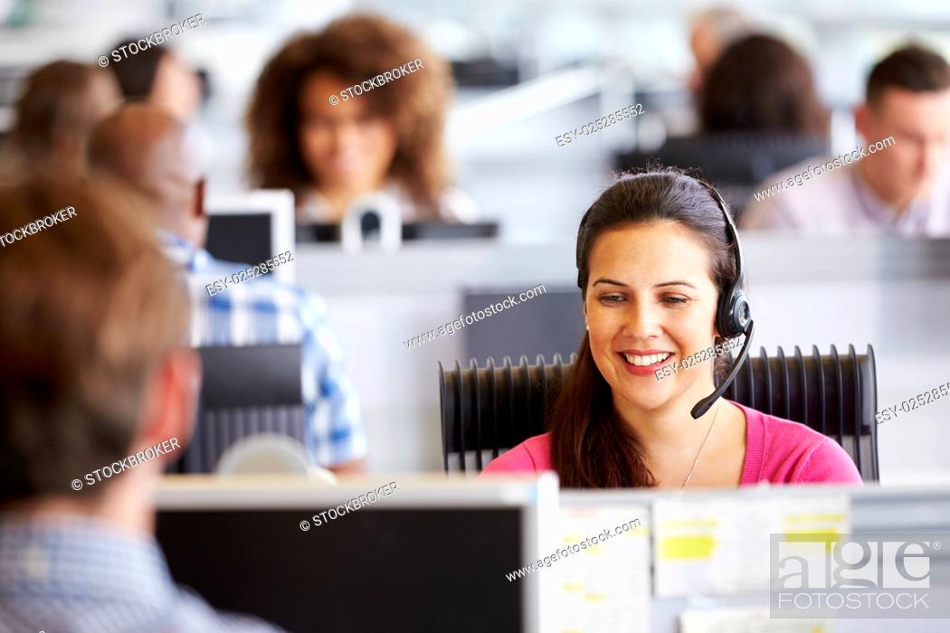Stock Photo: Young woman working in call centre, surrounded by colleagues.