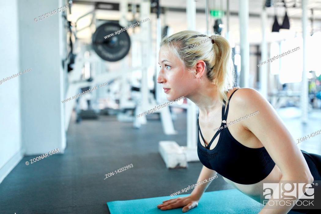 Imagen: Junge Frau macht eine Pilates oder Yoga Übung auf der Matte im Gymnastik Kurs.