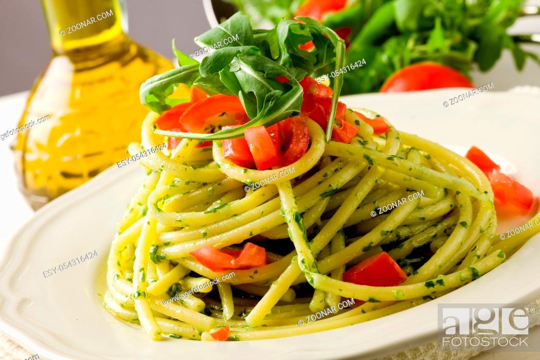 Stock Photo: photo of delicious pasta with arugula pesto and cherry tomatoes.