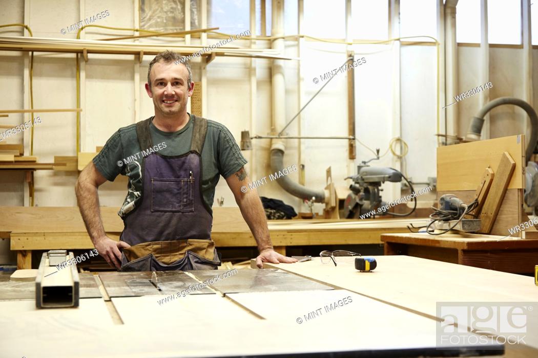 Stock Photo: Carpenter smiling in workshop.