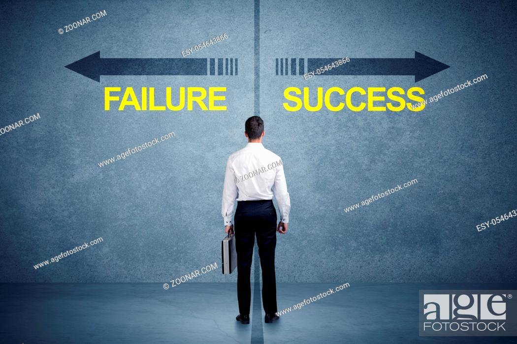 Stock Photo: Businessman standing in front of success and failure arrow concept on grungy background.