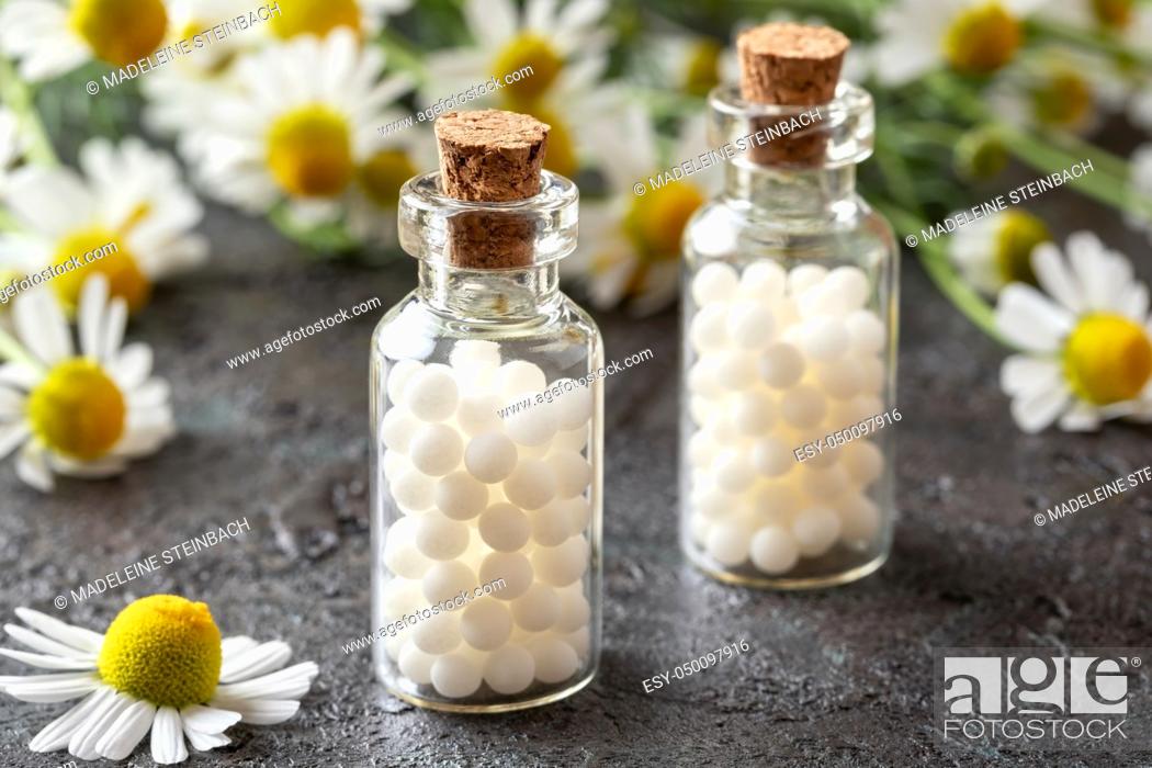 Stock Photo: Bottles of homeopathic remedies with fresh chamomile flowers.