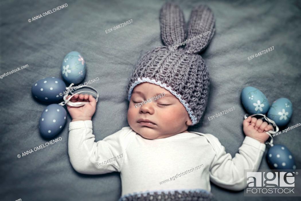 Stock Photo: Portrait of a cute little baby boy wearing bunny costume and holding decorative eggs in hands, happy Easter holiday.