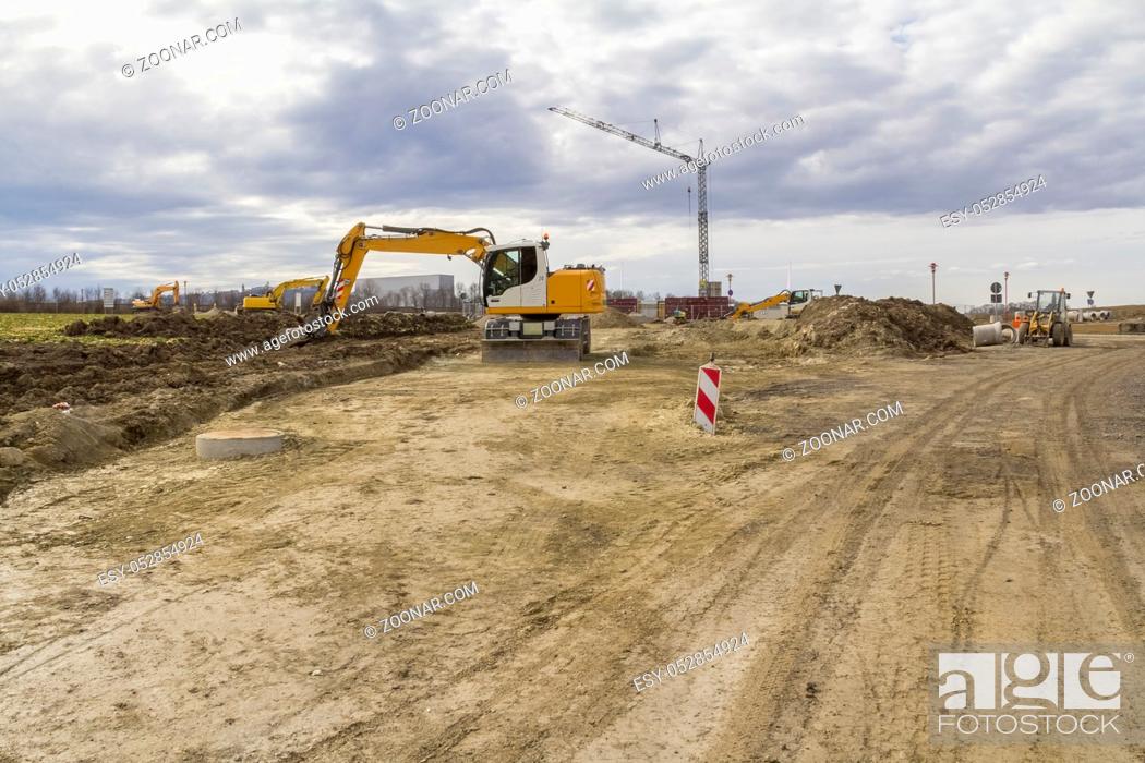 Stock Photo: excavator and other construction machines at a loamy construction site.
