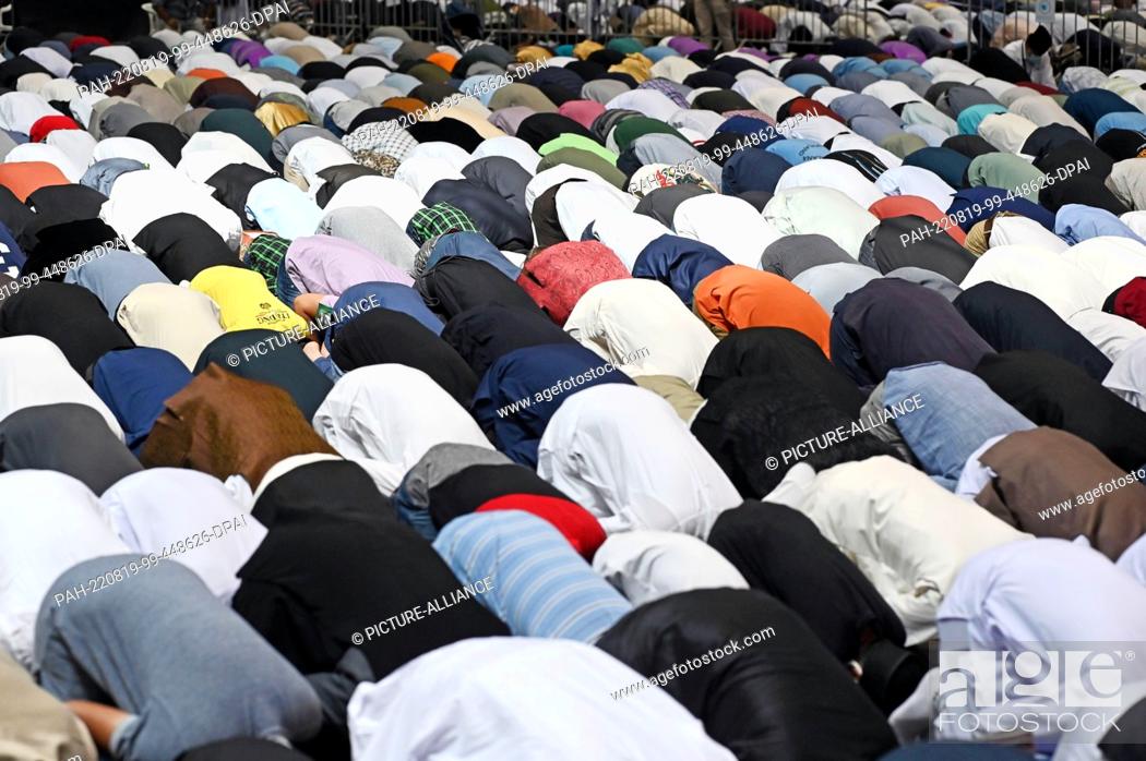 Stock Photo: 19 August 2022, Baden-Wuerttemberg, Karlsruhe: Members of the Islamic community Ahmadiyya Muslim Jamaat (AMJ) take part in Friday prayers at Messe Karlsruhe.