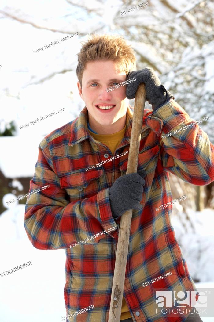 Stock Photo: Young man clearing snow.