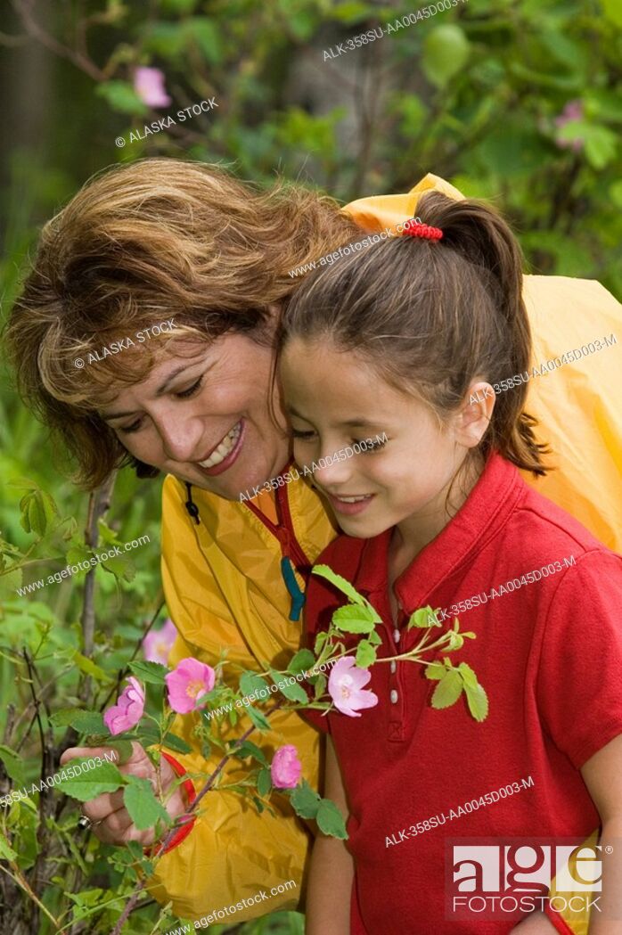 Mother Daughter Enjoy Flowers W Father Looking On Botanical
