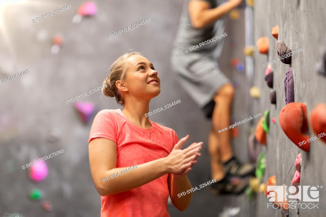 Stock Photo: man and woman climbing a wall at indoor gym.