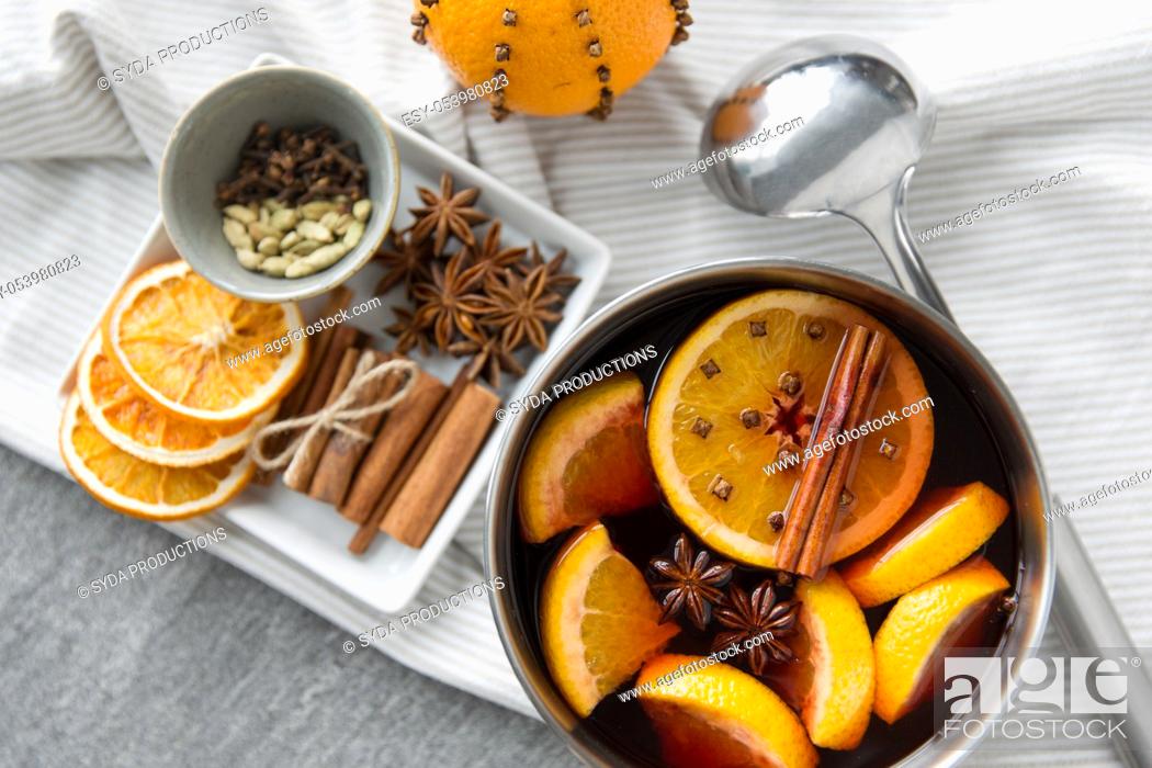 Stock Photo: pot with hot mulled wine, orange slices and spices.