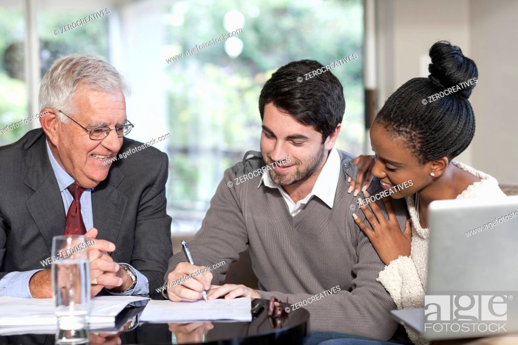 Stock Photo: Young couple having a meeting with a salesman.