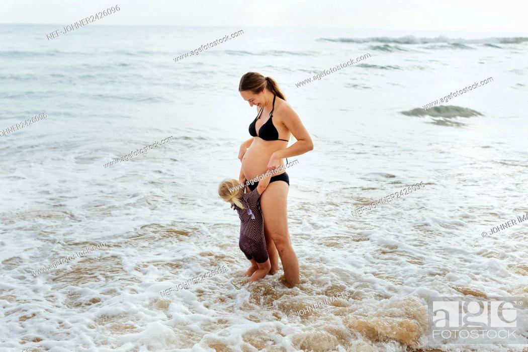 Stock Photo: Pregnant woman with daughter at sea.