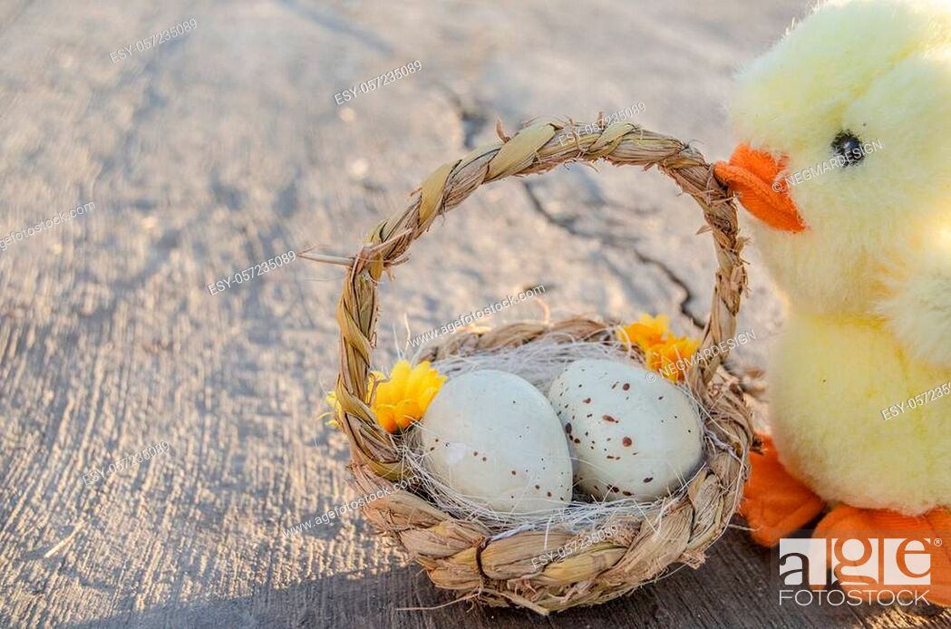 Stock Photo: cute little chicken toy and basket with two easter eggs on the stone path - easter concept.