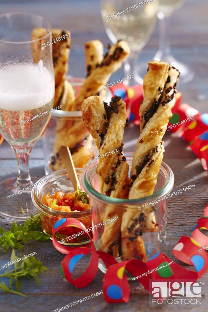 Stock Photo: Puff pastry olive bread sticks with tomato salsa in a jar.