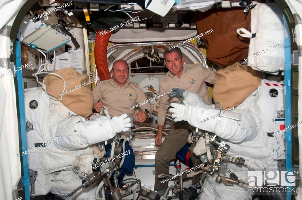 Stock Photo: NASA astronauts Garrett Reisman (left) and Michael Good, both STS-132 mission specialists, pose for a photo between two Extravehicular Mobility Unit (EMU).