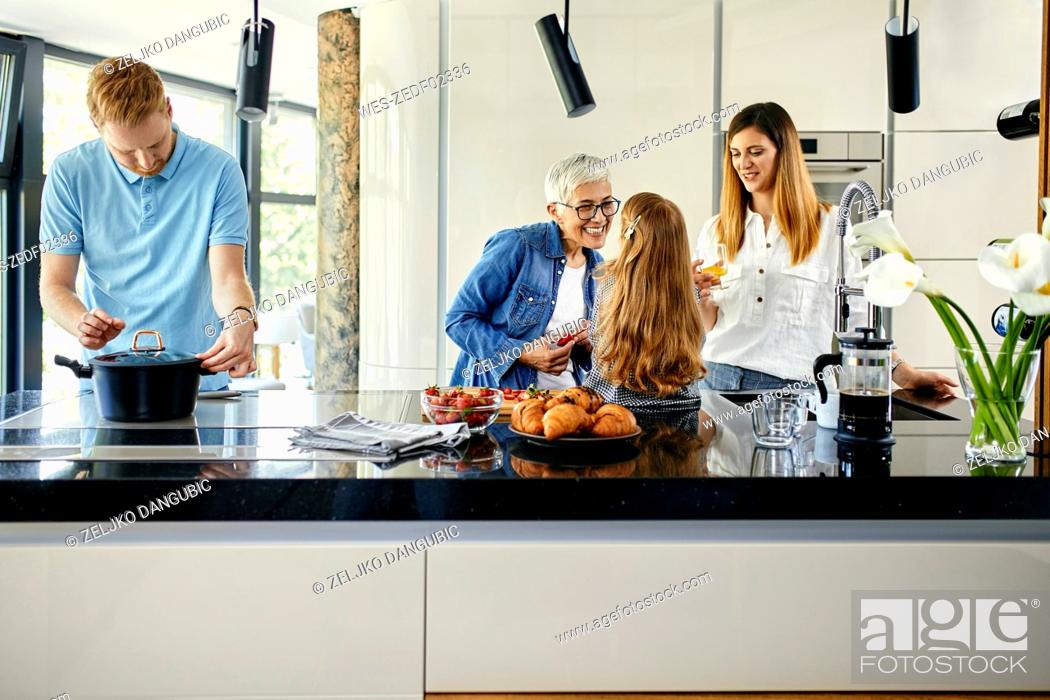 Stock Photo: Three genaration family preparing food in kitchen.