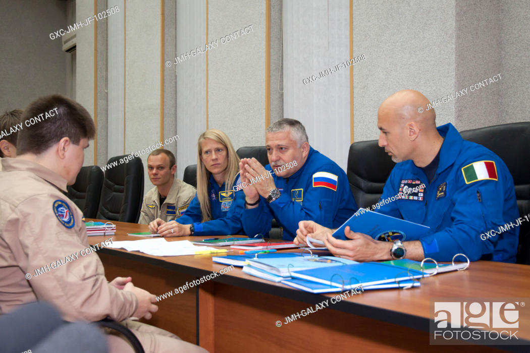Stock Photo: In the Cosmonaut Hotel crew quarters in Baikonur, Kazakhstan, Expedition 3637 Soyuz Commander Fyodor Yurchikhin (center) listens to a briefing on flight data.