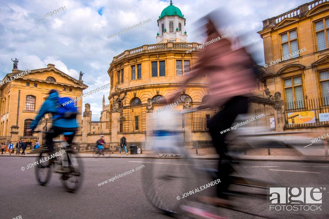 Stock Photo: Cyclists passing the Sheldonian Theatre, Oxford, Oxfordshire, England, United Kingdom, Europe.