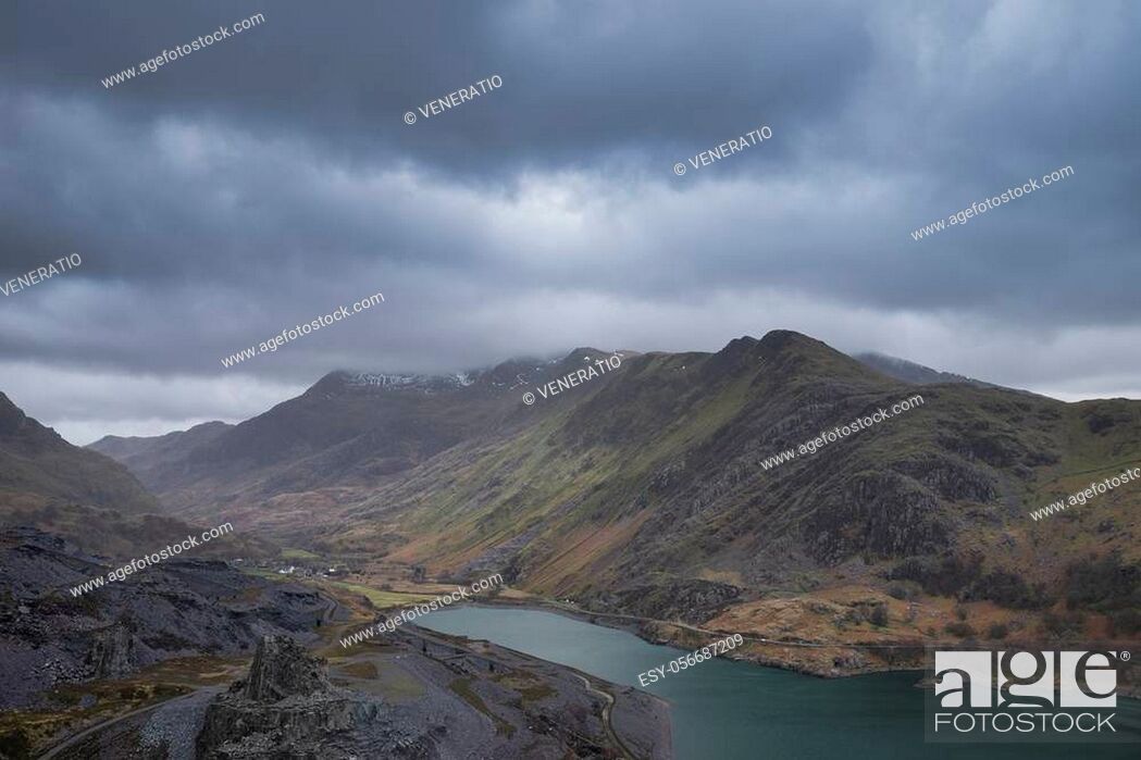 Stock Photo: Stunning landscape image of Dinorwig Slate Mine and snowcapped Snowdon mountain in background during Winter in Snowdonia with Llyn Peris in foreground.