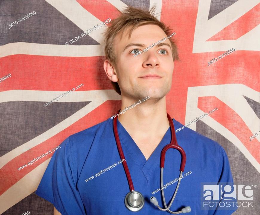 Imagen: Confident male surgeon looking up with British Flag in background.