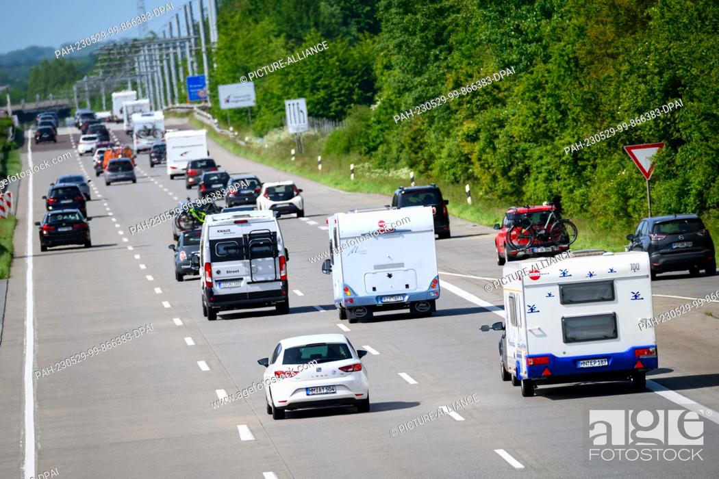 Stock Photo: 29 May 2023, Schleswig-Holstein, Hamberge: Motorhomes and cars drive on the A1 freeway at the Lübeck interchange. For the Whitsun weekend.
