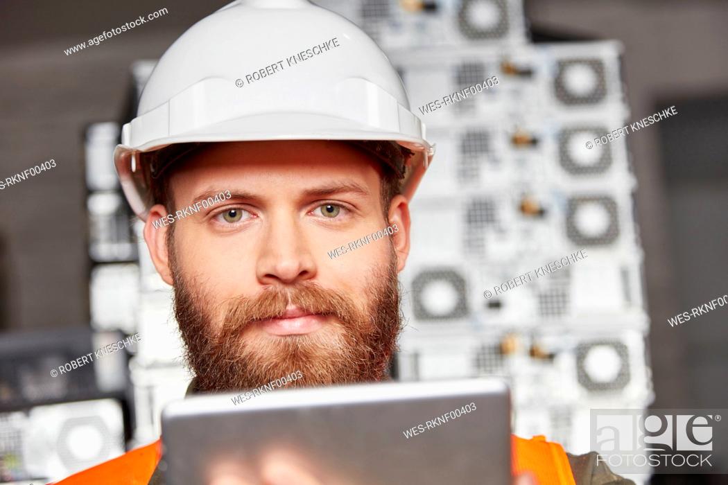 Stock Photo: Worker in computer recycling plant using digital tablet.
