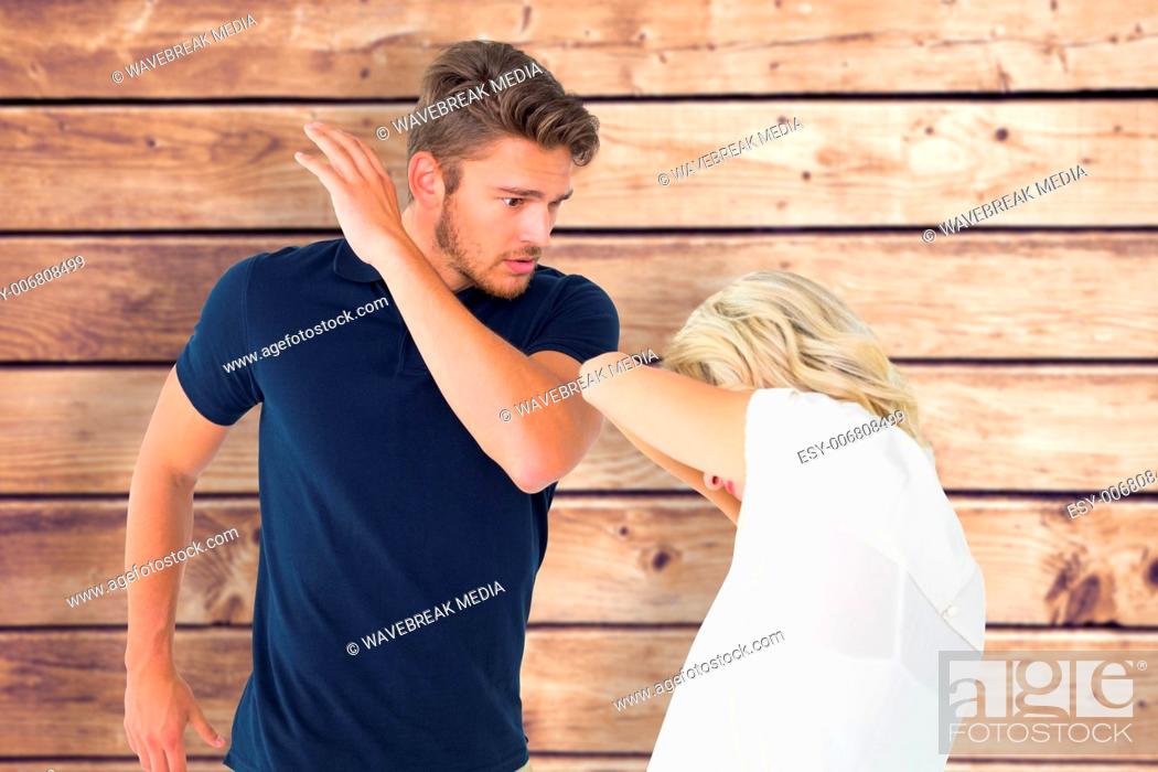Stock Photo: Composite image of angry man about to hit his girlfriend.