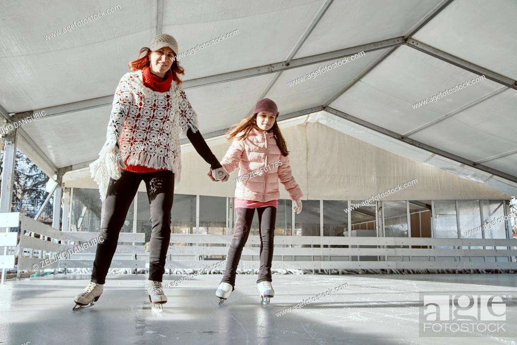 Stock Photo: Mother holding hand of her daughter , while ice skating.