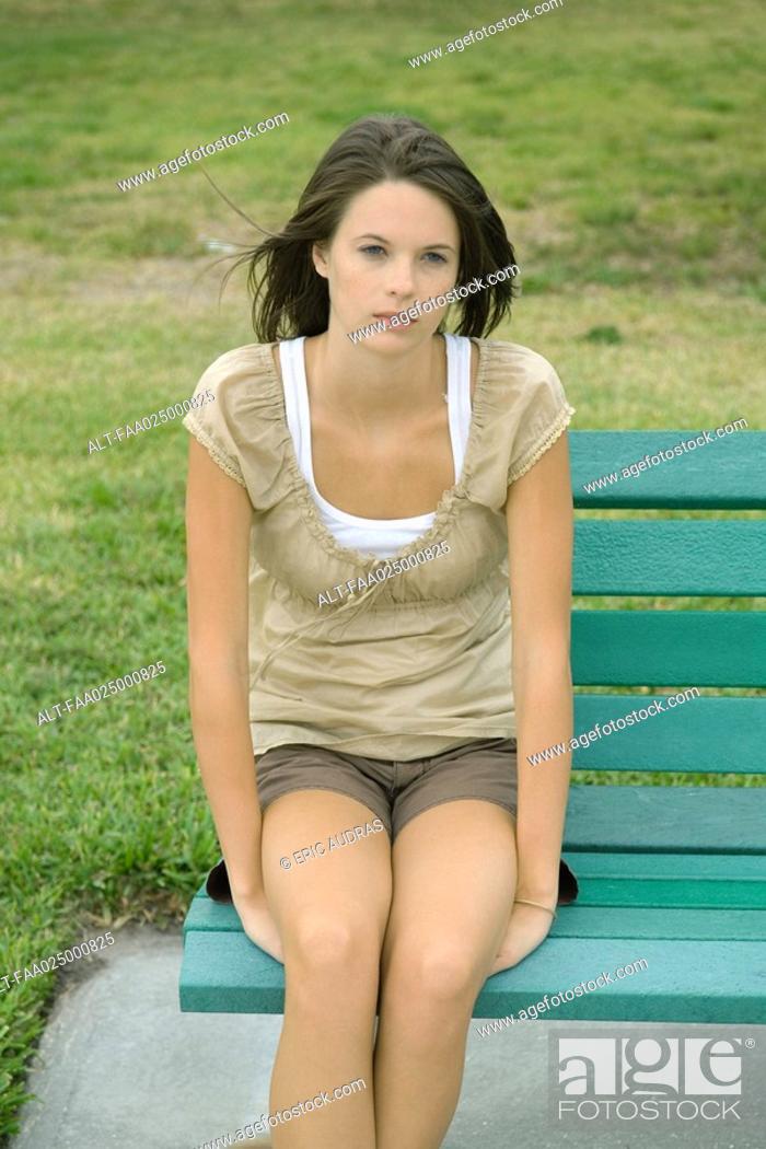 Teenage girl sitting on bench, looking away, Stock Photo, Picture And ...