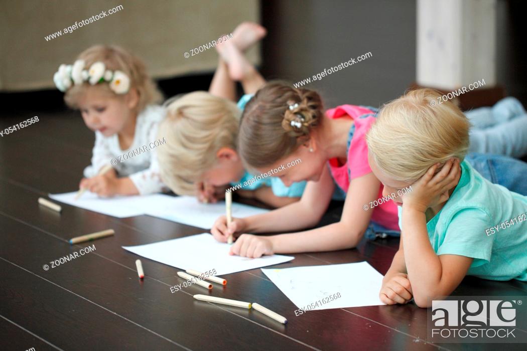 Stock Photo: Group of cute children drawing with colorful pencils on floor.