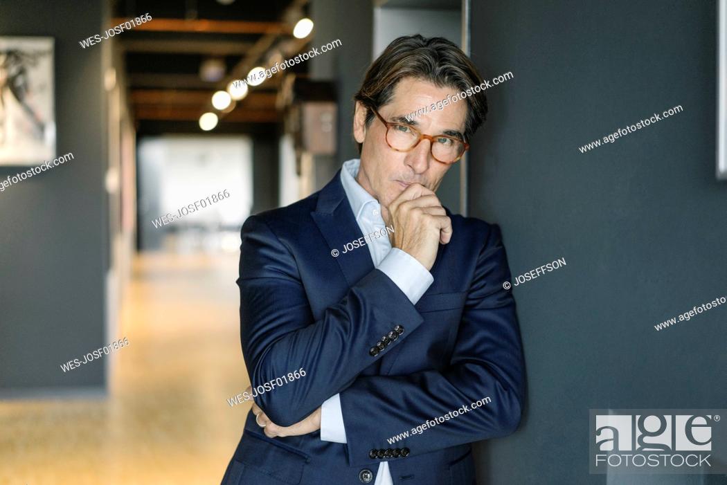 Stock Photo: Portrait of businessman wearing glasses in office.