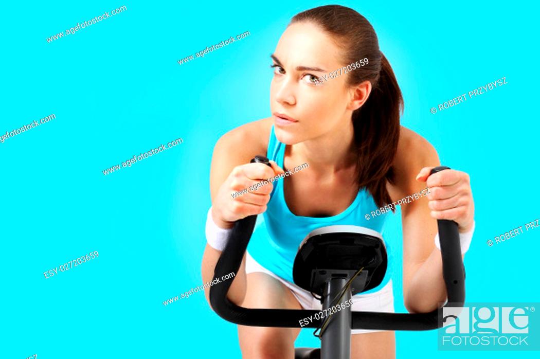 Stock Photo: spinning woman exercising on a stationary bike\nexercise bike, effective form of exercise\nexercise on a stationary bike, a woman in a fitness club.