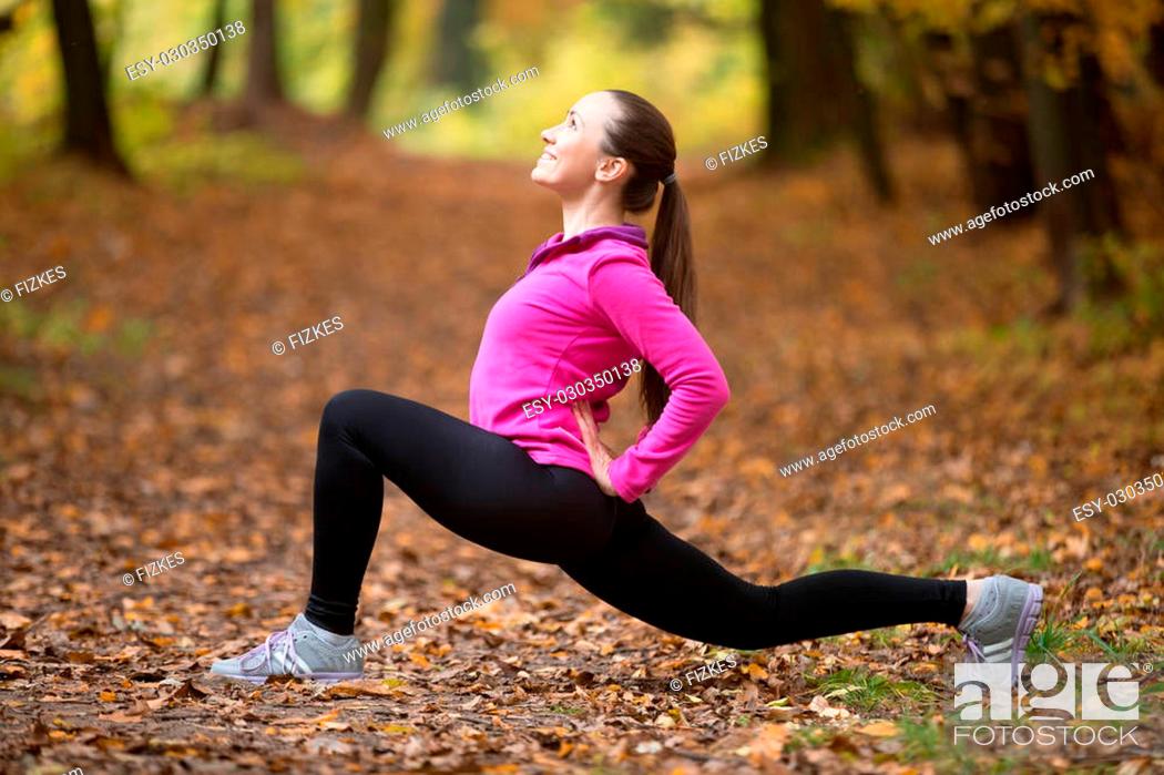 Stock Photo: Sporty beautiful happy young woman practicing yoga, standing in low lunge exercise, anjaneyasana, ashwa sanchalanasana, working out outdoor on autumn day.