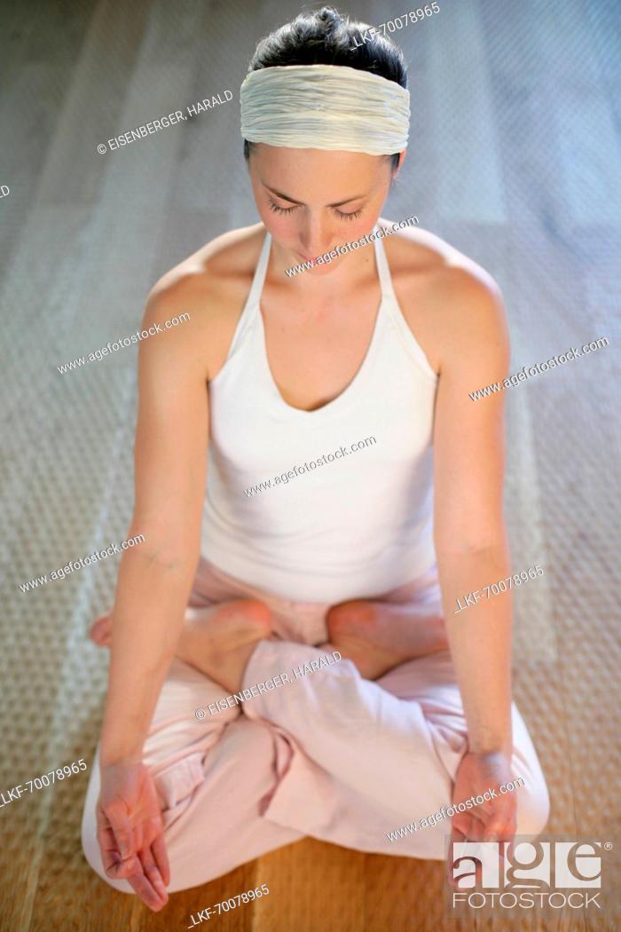 Stock Photo: Young woman practising yoga, lotus position.