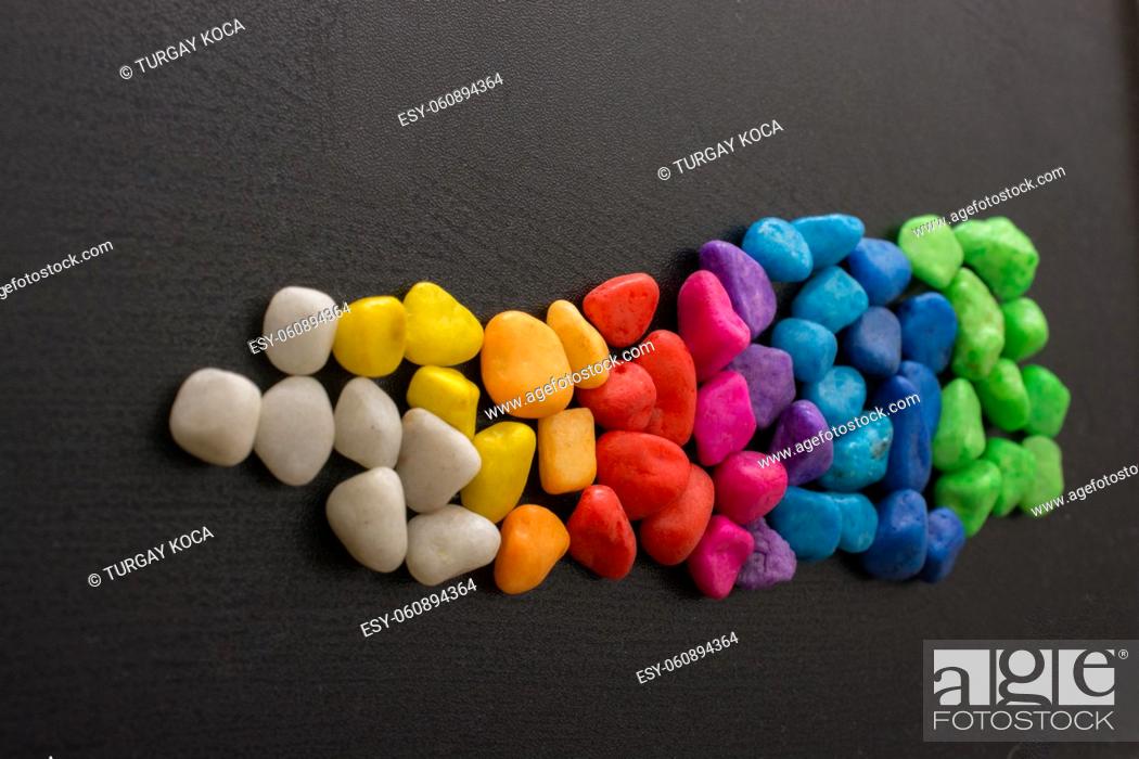 Stock Photo: Pile of little colorful pebbles on black background.