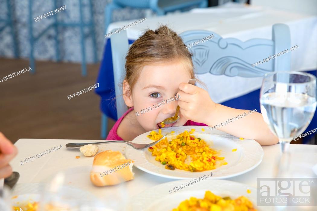 four years old blonde girl eating Spanish paella rice with spoon from white  plate, Stock Photo, Picture And Low Budget Royalty Free Image. Pic.  ESY-041230987 | agefotostock