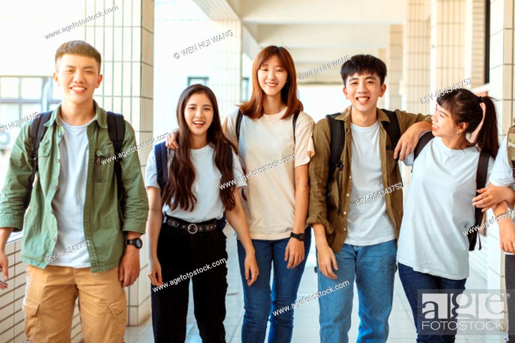 Stock Photo: Group of happy students walking along the corridor at college.