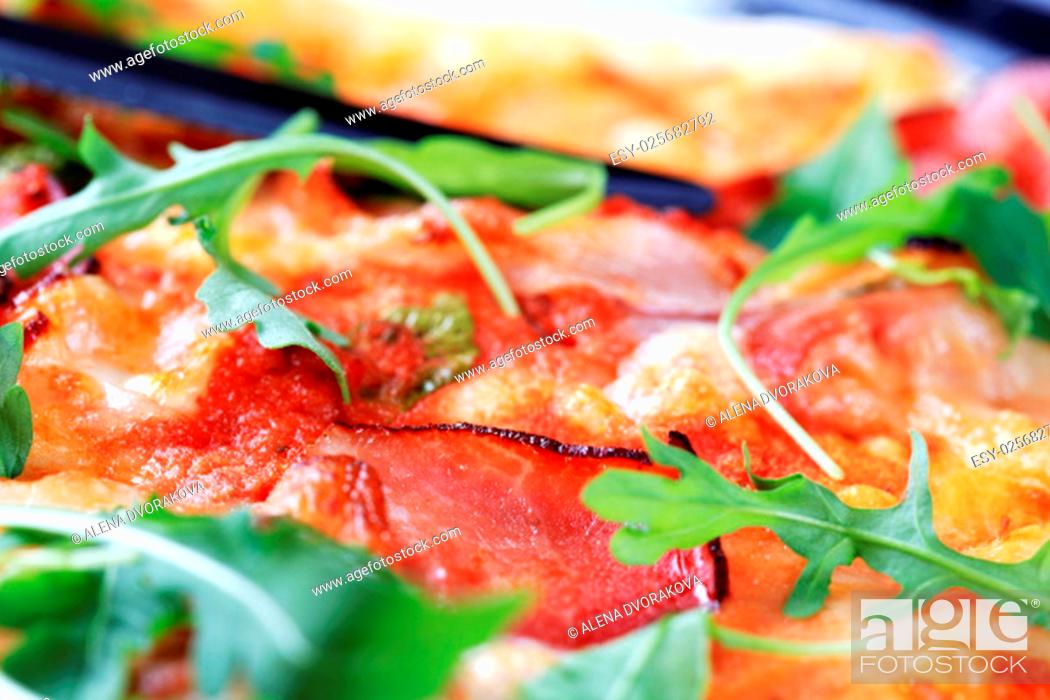 Stock Photo: Slices of prosciutto ham on pizza - macro.