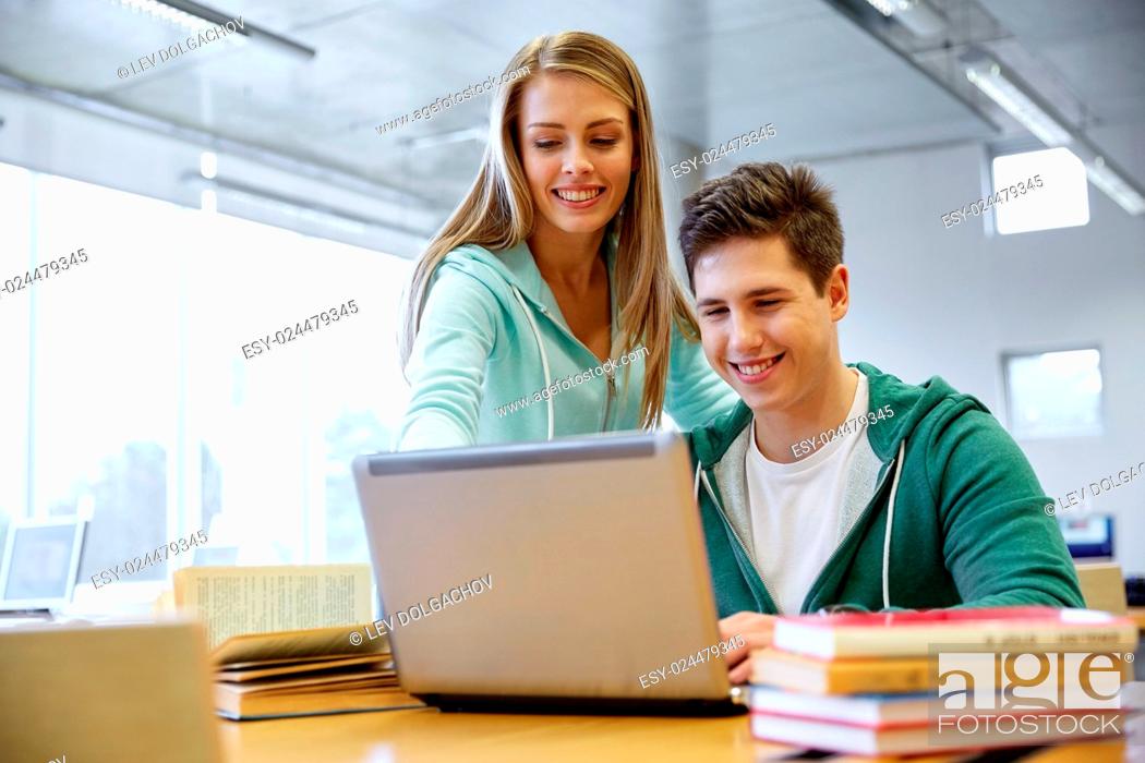 Stock Photo: education, people, technology and learning concept - happy high school students with laptop computer in classroom or library.